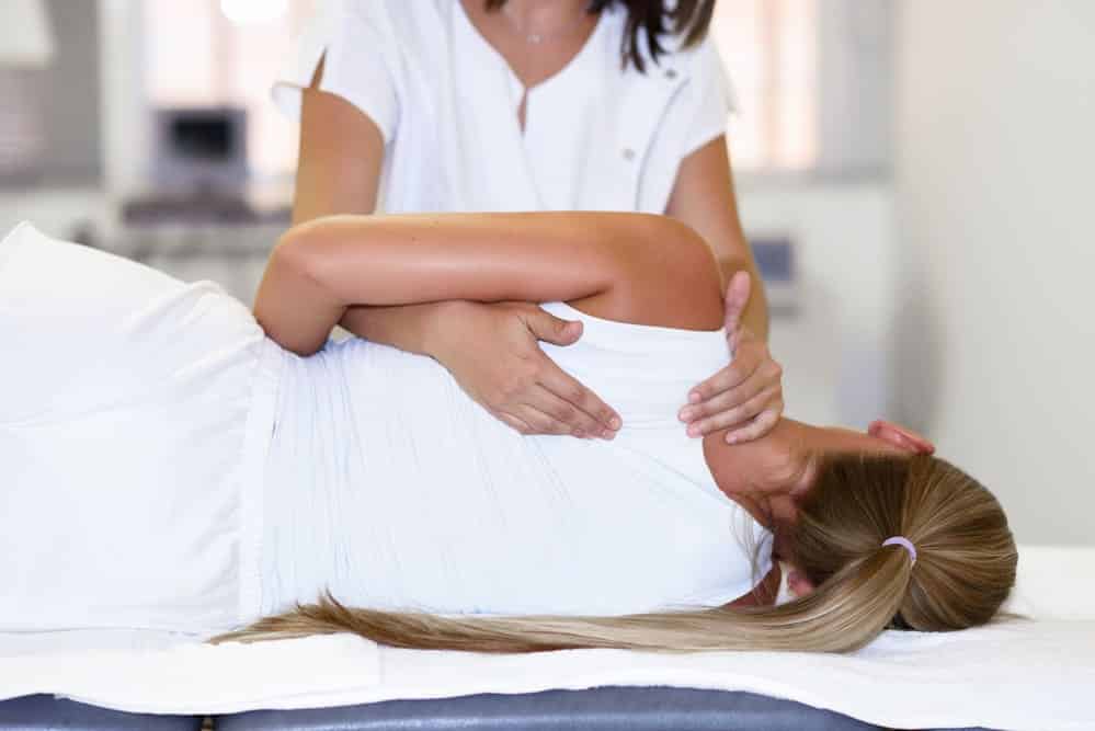 profesional mujer fisioterapeuta dar hombro masaje rubio mujer