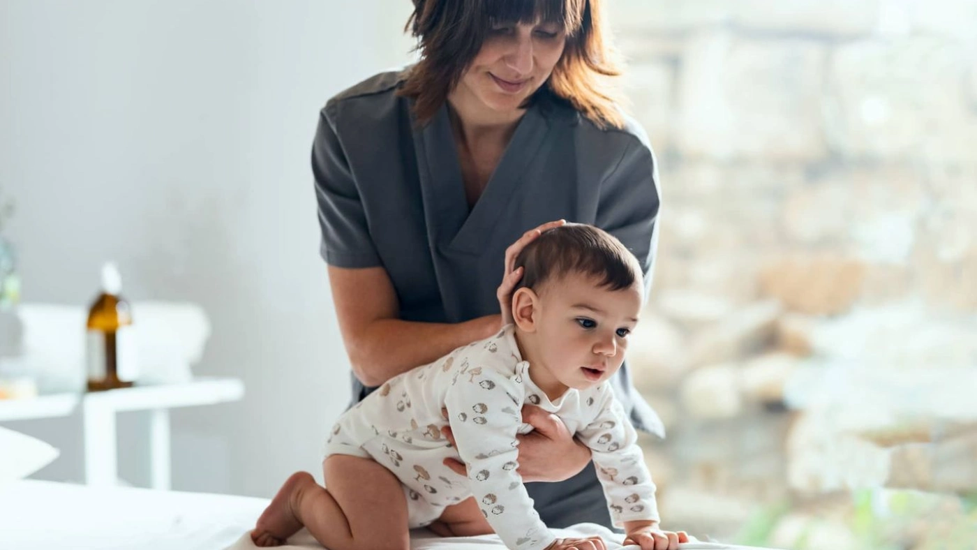 fisio con un bebe en la camilla