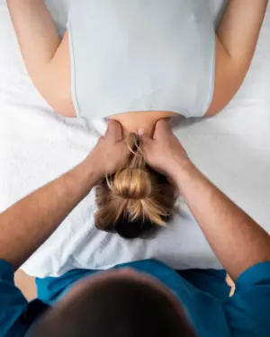 fisioterapeuta masajeando el cuello de una paciente