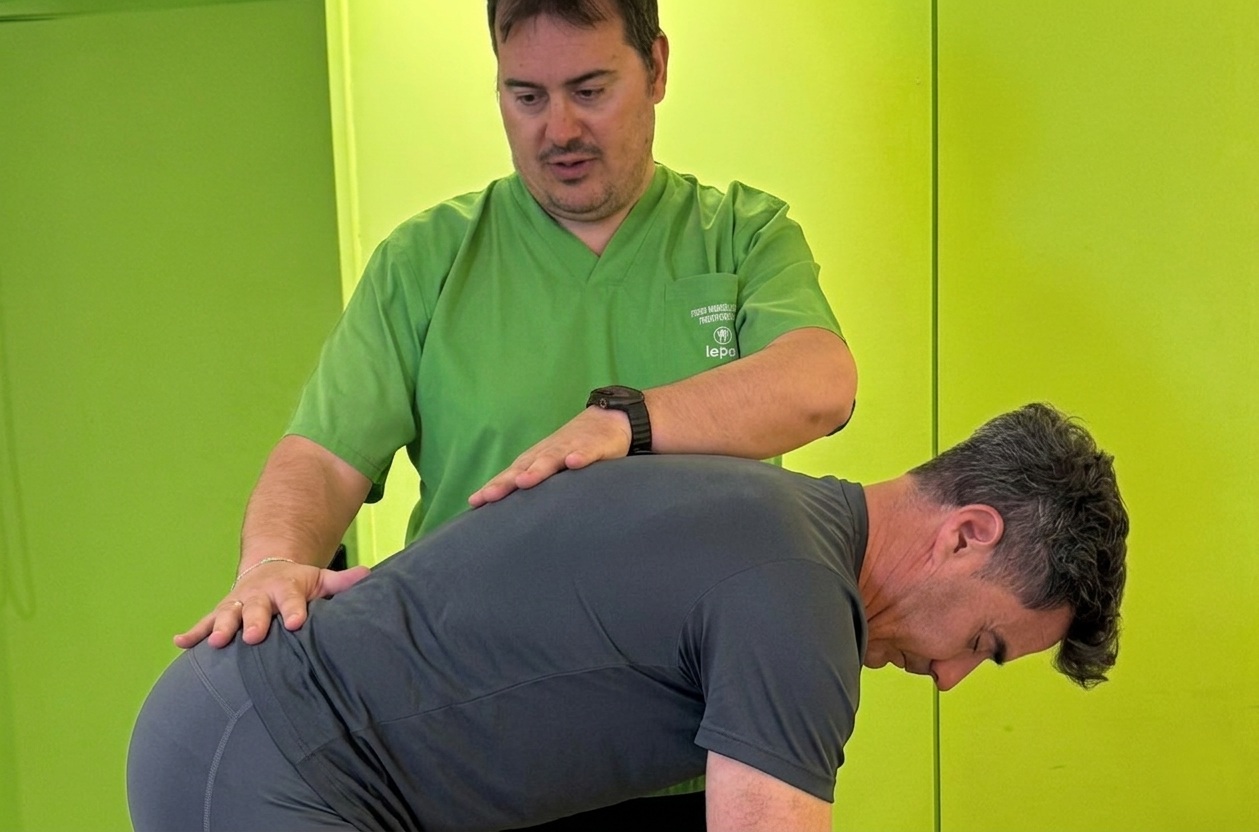 fisioterapeuta revisando columna del paciente