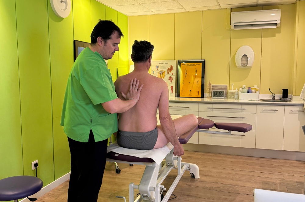 fisioterapeuta revisando espalda de paciente